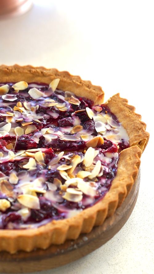 Free Tantalizing homemade berry tart topped with sliced almonds, perfect for dessert lovers. Stock Photo