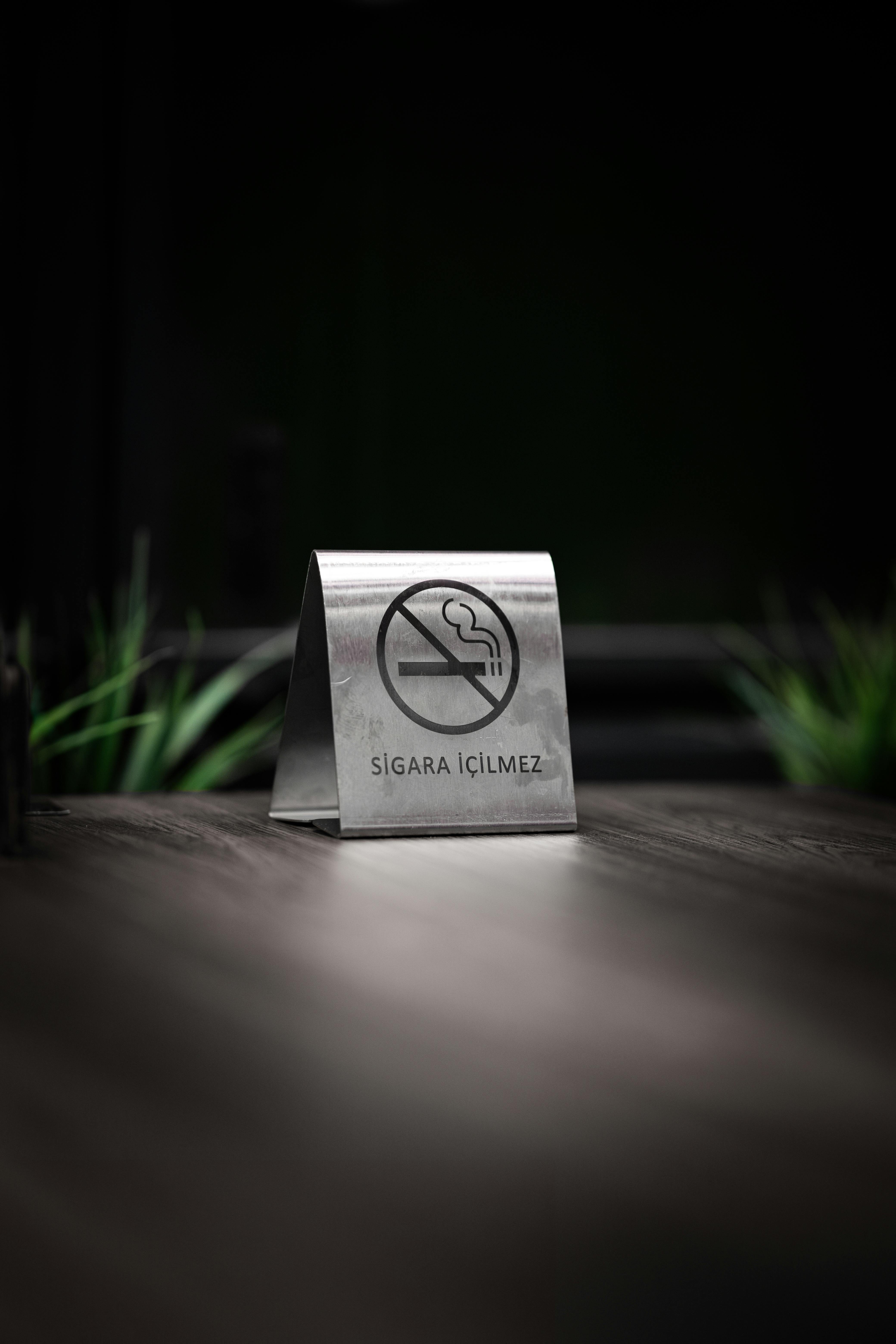 Gratis Cartello In Metallo "Vietato Fumare" Su Tavolo In Legno Scuro Foto a disposizione