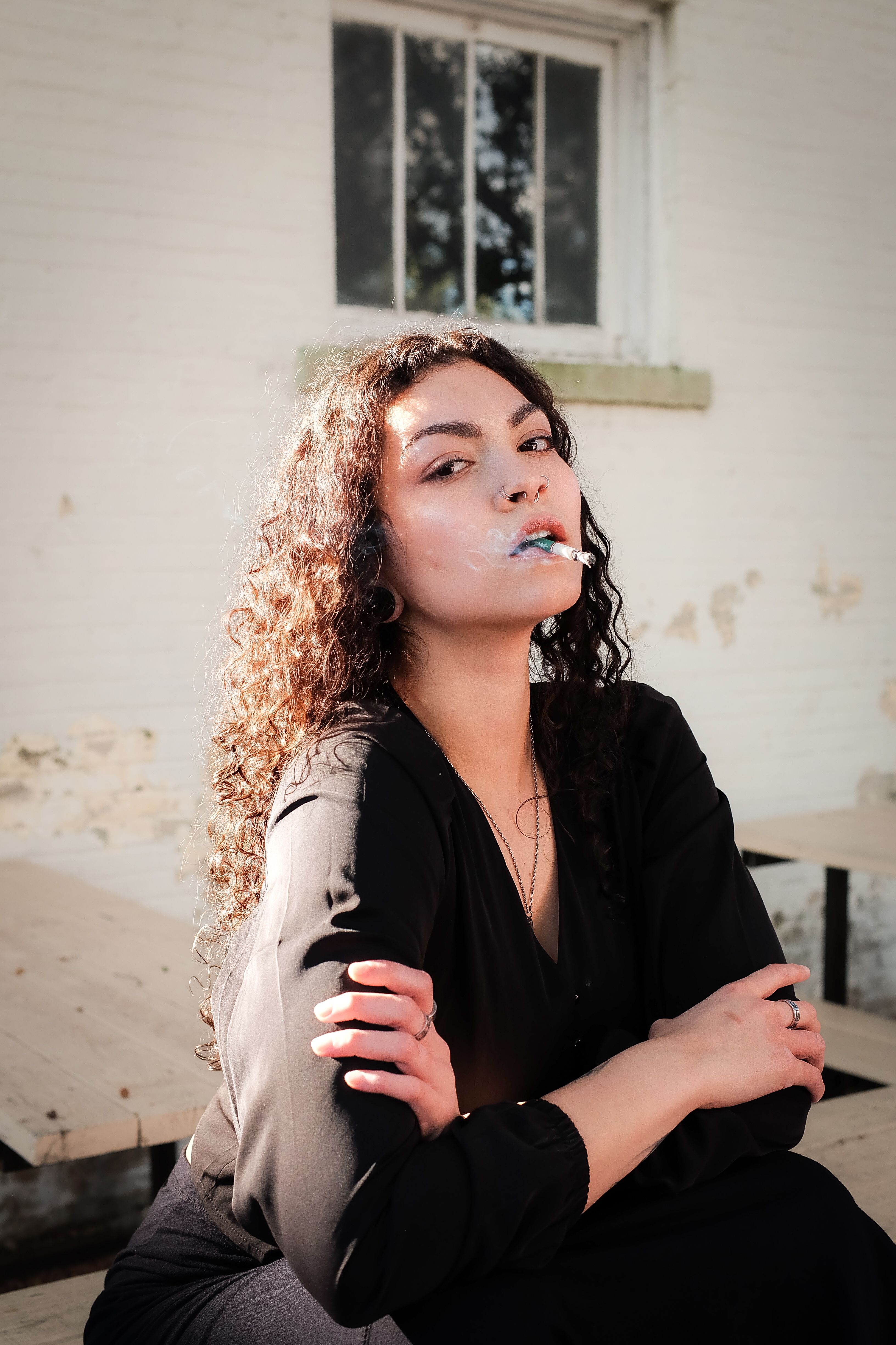 Portrait of a woman blowing bubble gum outdoors, exuding confidence and style.