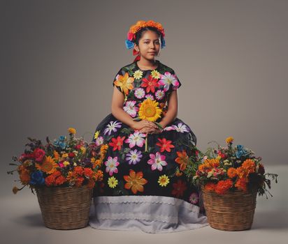 Vibrant portrait of a young girl in traditional Oaxacan dress, adorned with flowers, embodying cultural heritage.
