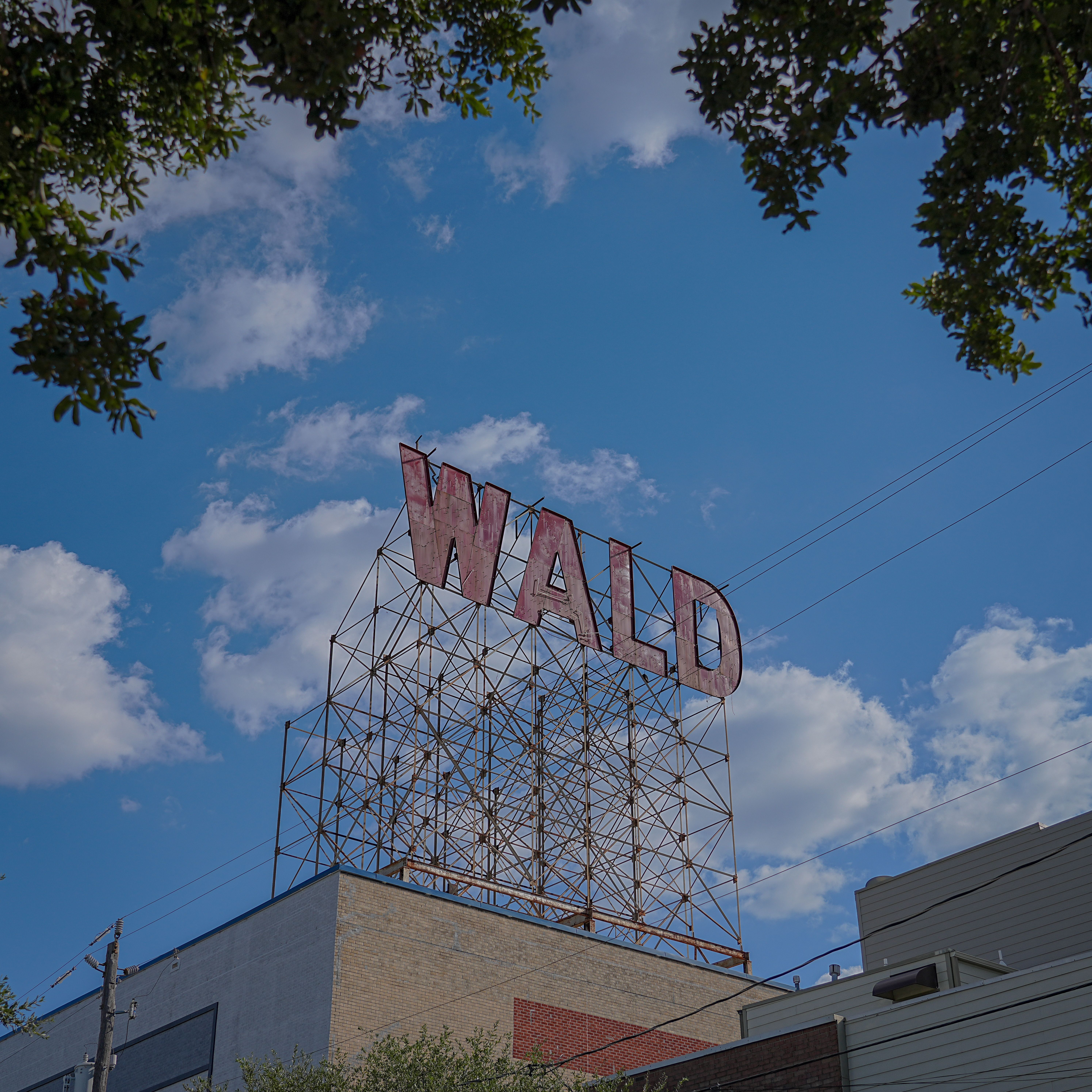 Historic WALD sign with open sky and wispy clouds, perfect for cityscapes.