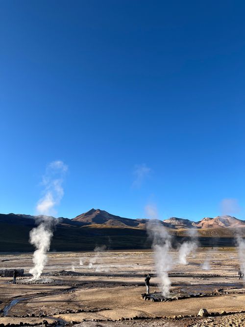 Free Steam rises from geysers against the backdrop of Chilean mountains at sunrise. Stock Photo