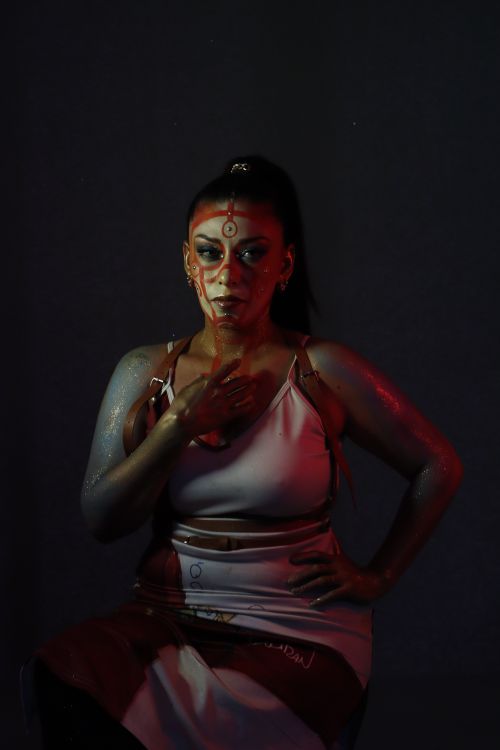 Free A woman with striking makeup poses in dramatic lighting. Stock Photo