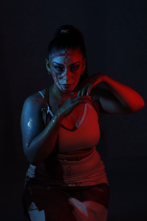 Free Captivating portrait with unique artistic makeup and dramatic red-blue lighting effects. Stock Photo
