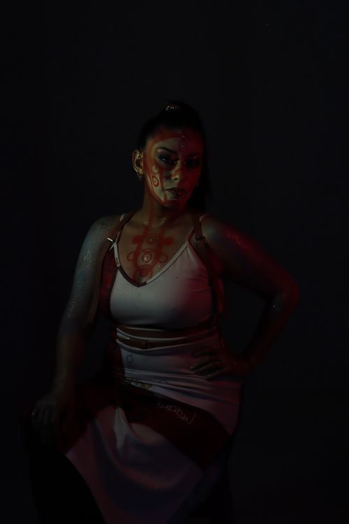 Free Artistic portrait of a woman in dim light with unique face paint and mood lighting. Stock Photo