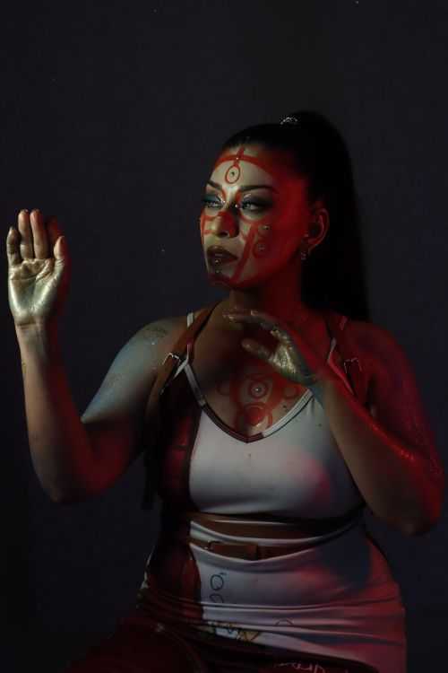 Free Creative portrait featuring a woman with vibrant body paint against a dark backdrop. Stock Photo