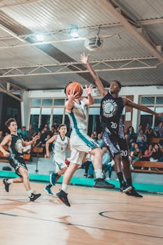 Intense basketball match with players in action on an indoor court.