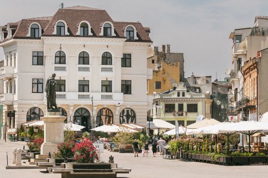 Historic square in Constanța, Romania with classic architecture and outdoor cafes.