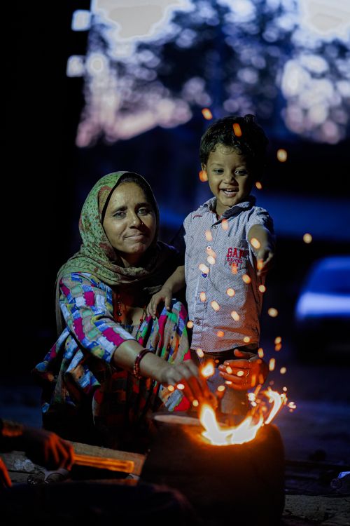 Free Mother and child enjoying a cozy evening by the fire outdoors. Stock Photo
