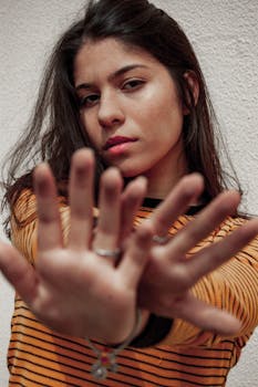 一位时尚的年轻女子穿着条纹毛衣，伸出双手摆姿势的肖像