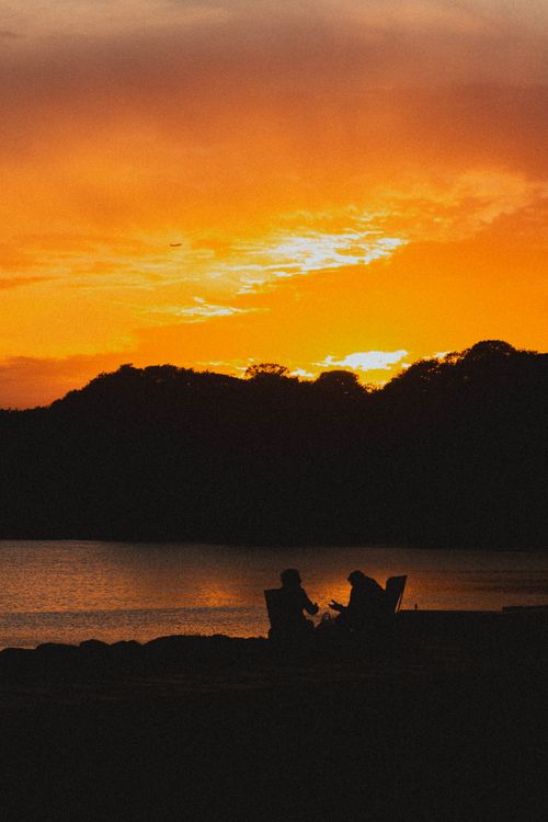 Free Romantic silhouettes of a couple enjoying the vibrant sunset over the Bosphorus Strait in Istanbul. Stock Photo