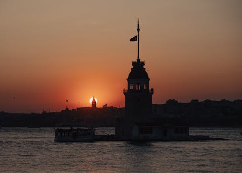 Silhouette of Maiden's Tower against a vivid sunset sky in Istanbul. Iconic scenery and warm tones.