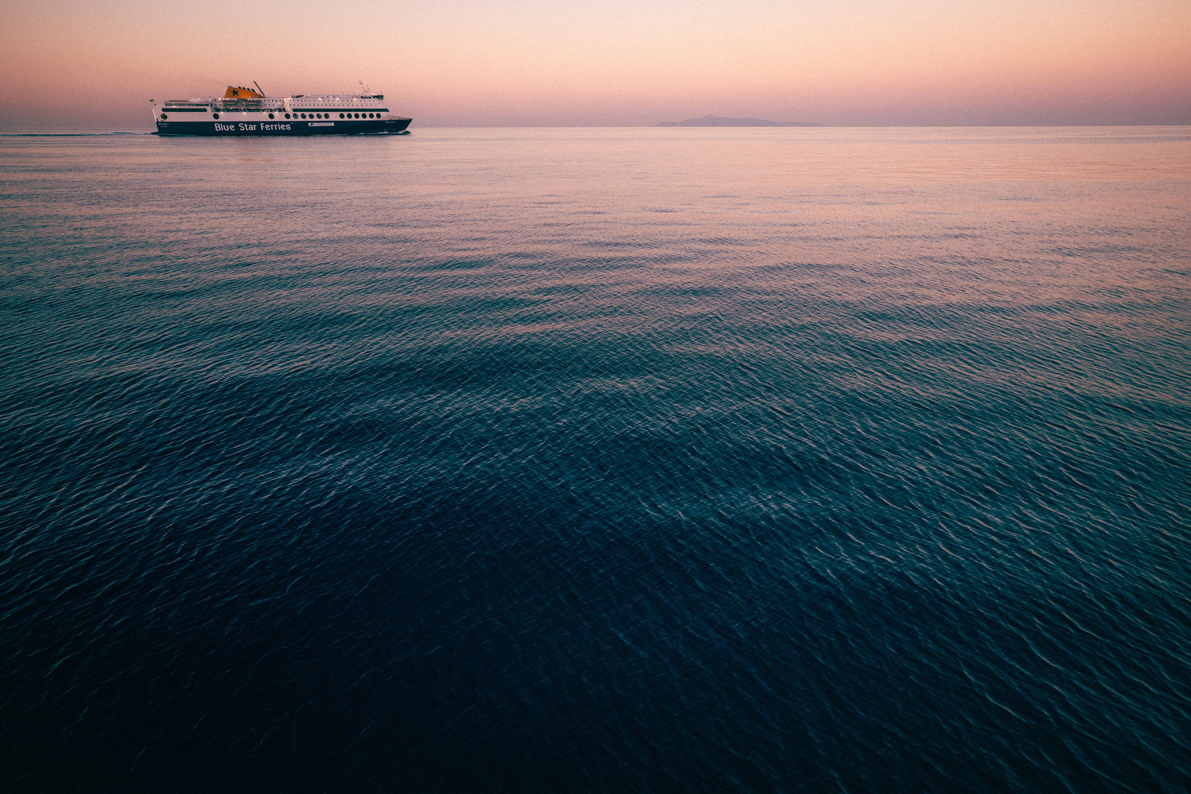 Serene Sunset with Ferry on Calm Ocean Waters · Free Stock Photo