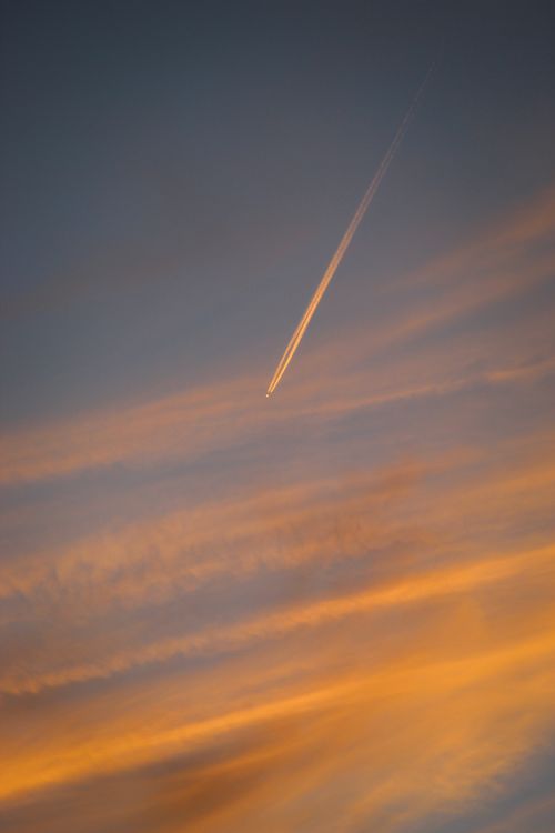 Free A beautiful sunset sky with a commercial airplane flying over Aachen, Germany. Stock Photo