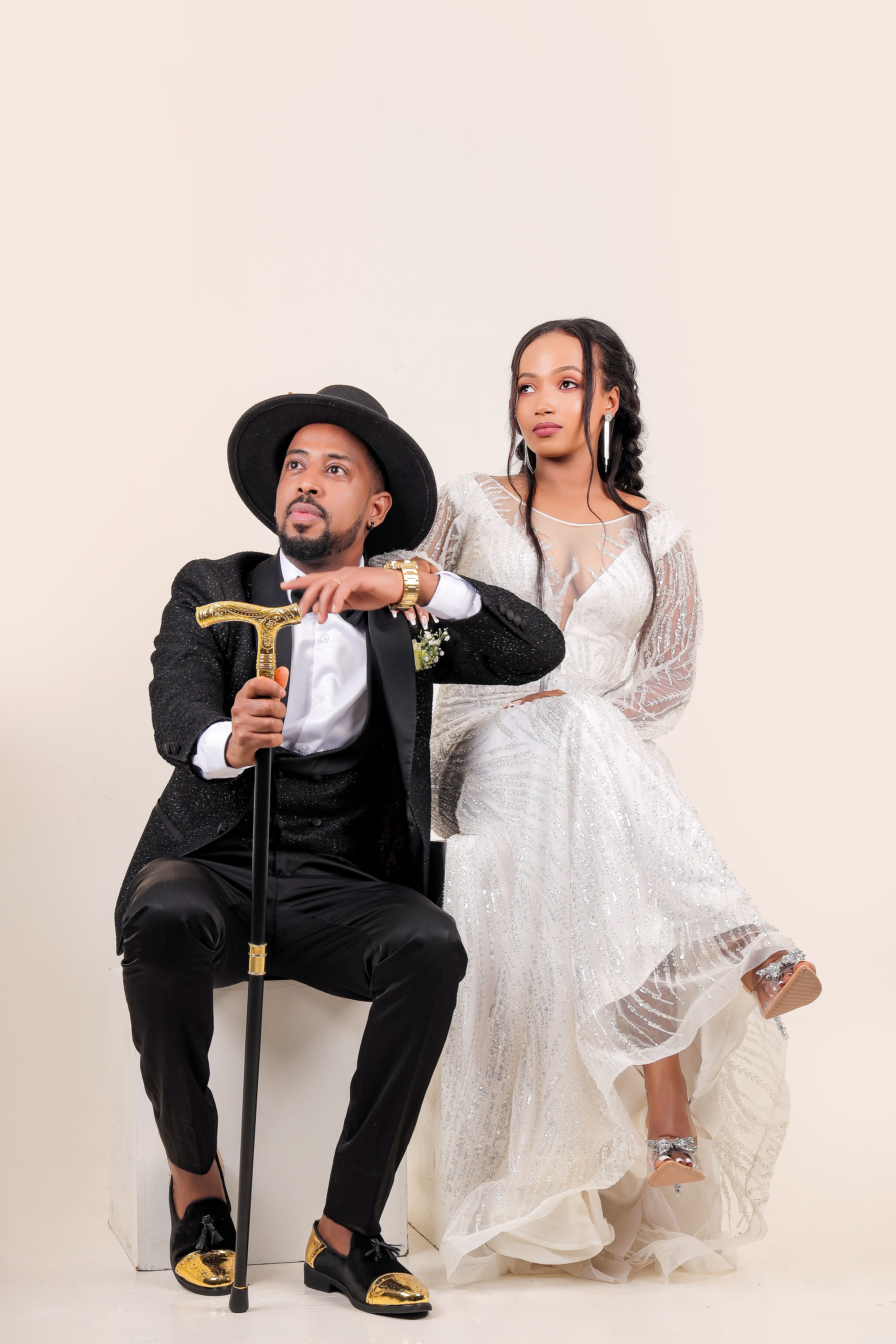 Elegant Couple in Formal Attire Seated on a Stool · Free Stock Photo