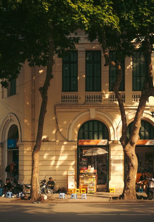 Free Sunlit afternoon street scene in Hanoi, featuring a classic colonial building. Stock Photo