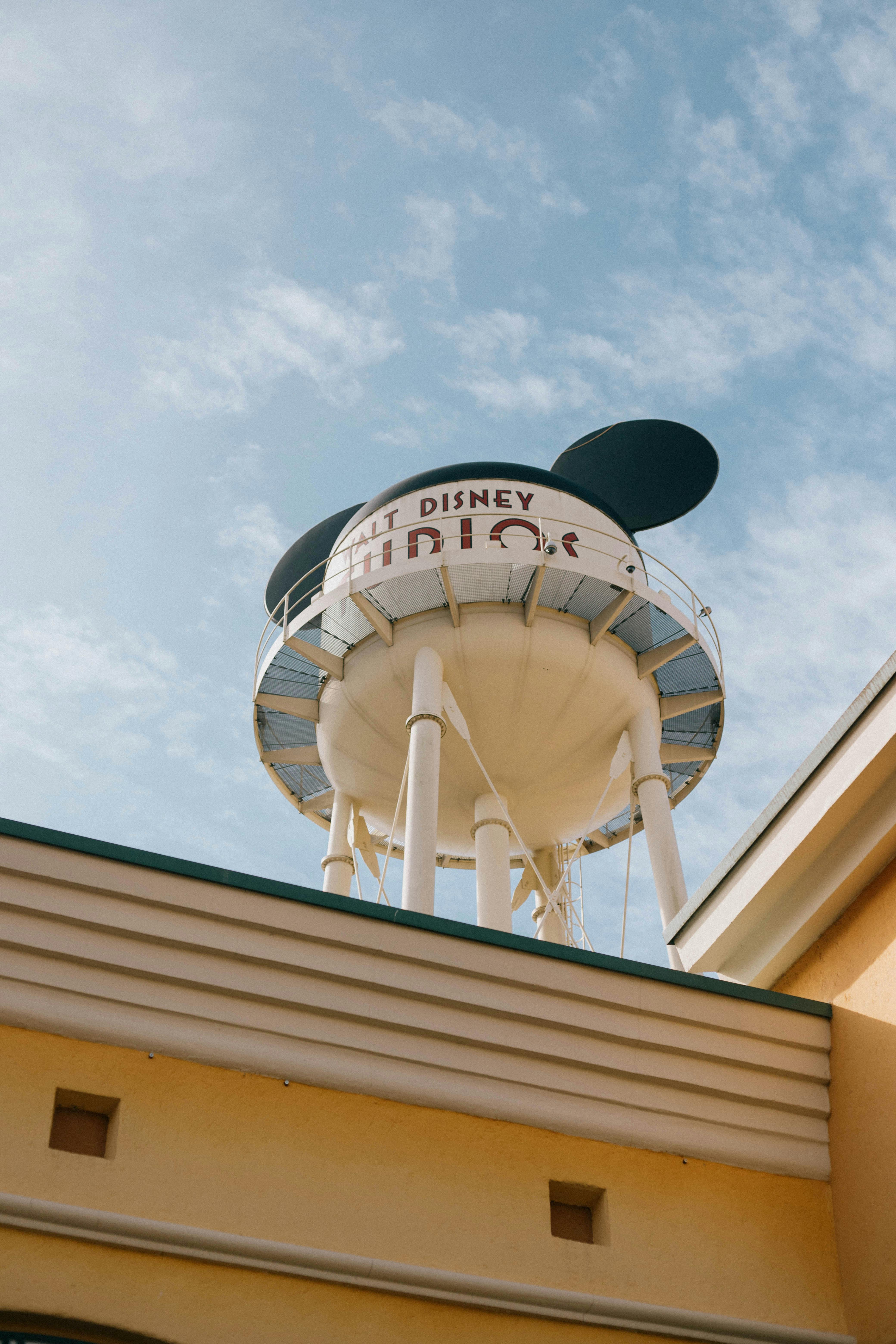 Iconic Walt Disney Studios water tower against a bright blue sky in Paris, France.