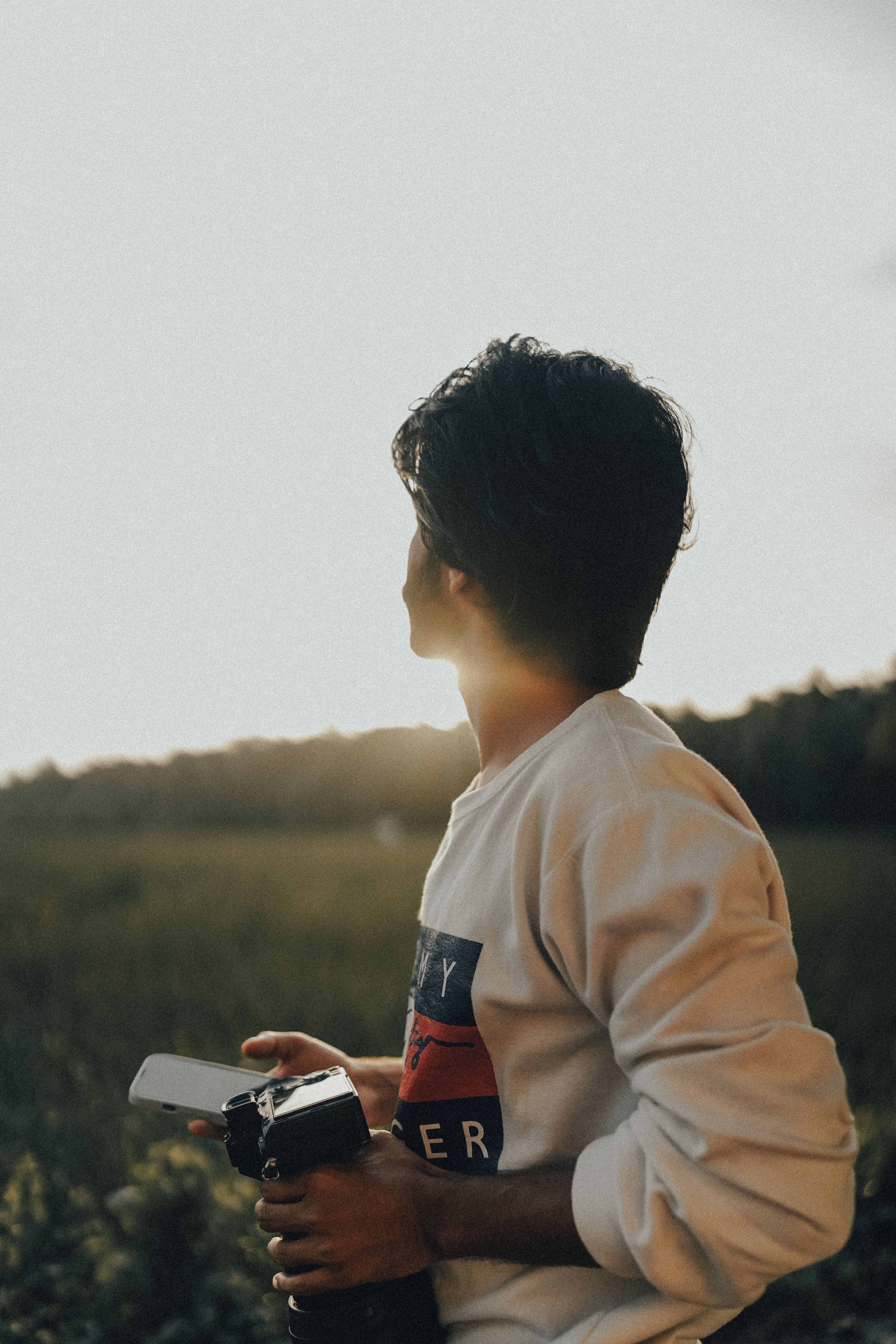 Young Man with Camera in Sunset Field Scenic · Free Stock Photo