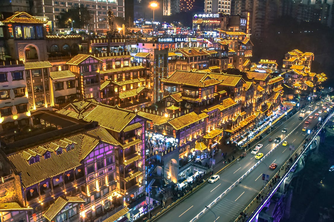 Free Stunning night view of illuminated traditional Chinese architecture in Chongqing's bustling cityscape. Stock Photo