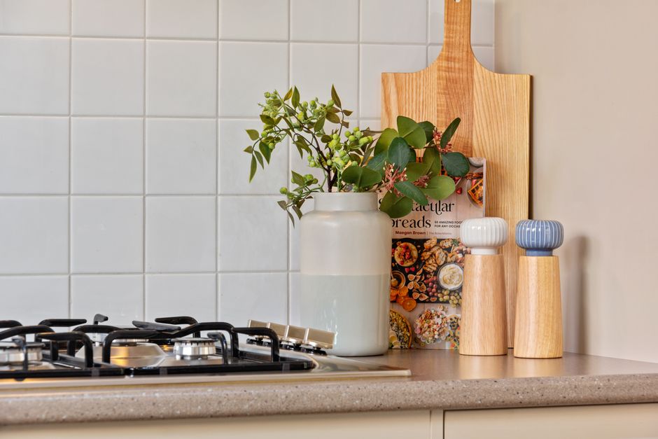 Photo by Martin Lang on Pexels Chic kitchen featuring a modern cooktop, decorative vases, and stylish tableware.