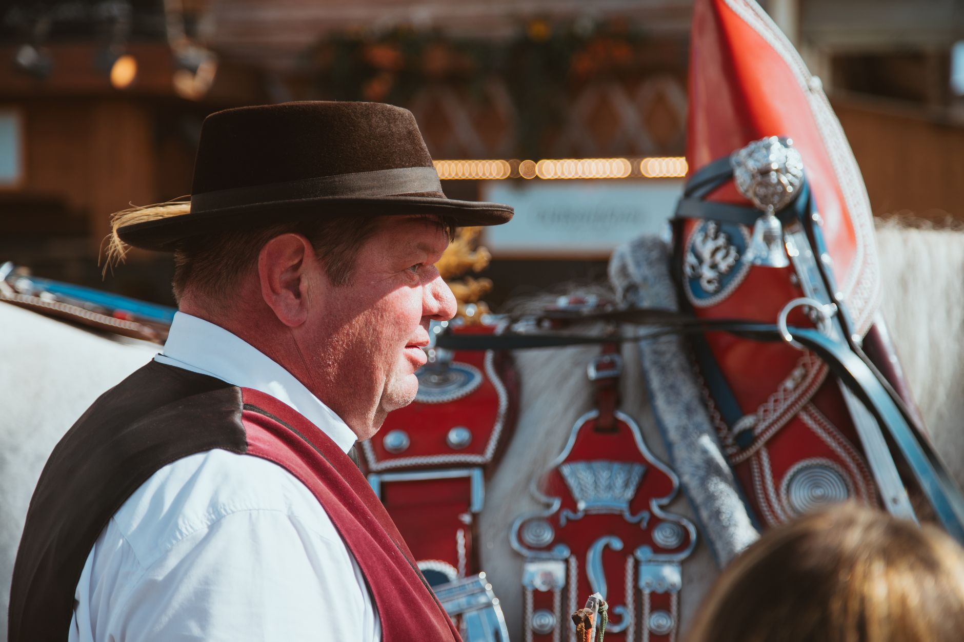 A man in traditional Bavarian costume with a decorated horse at Munich's Oktoberfest.