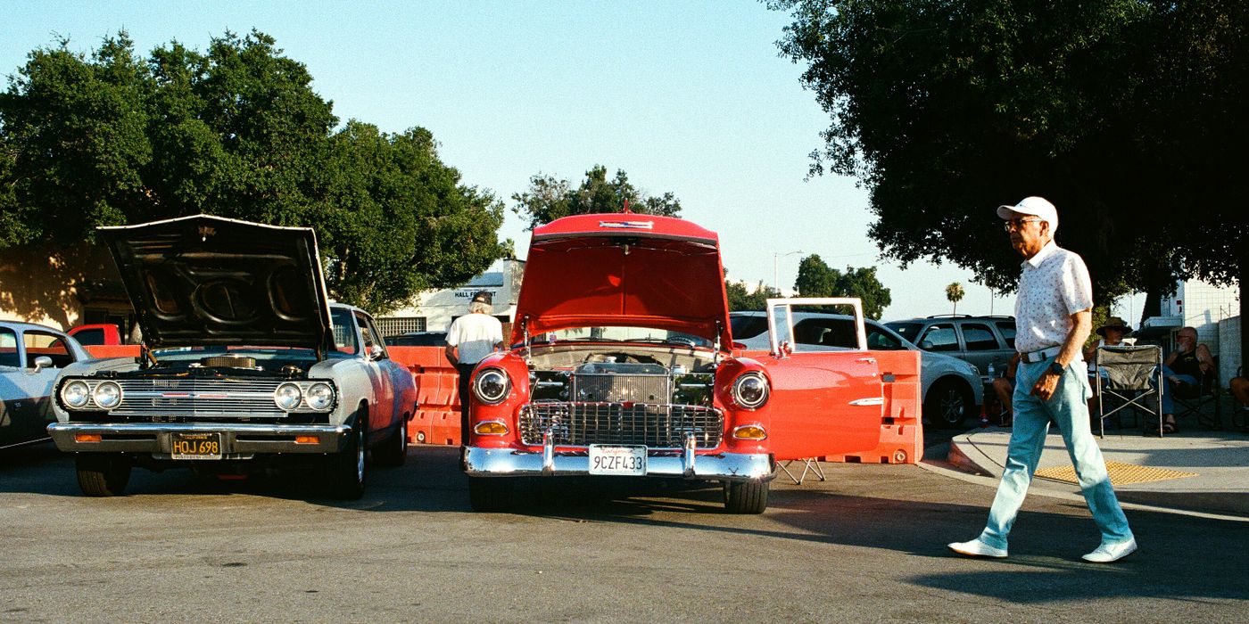 Classic cars with their hoods open at an outdoor car show