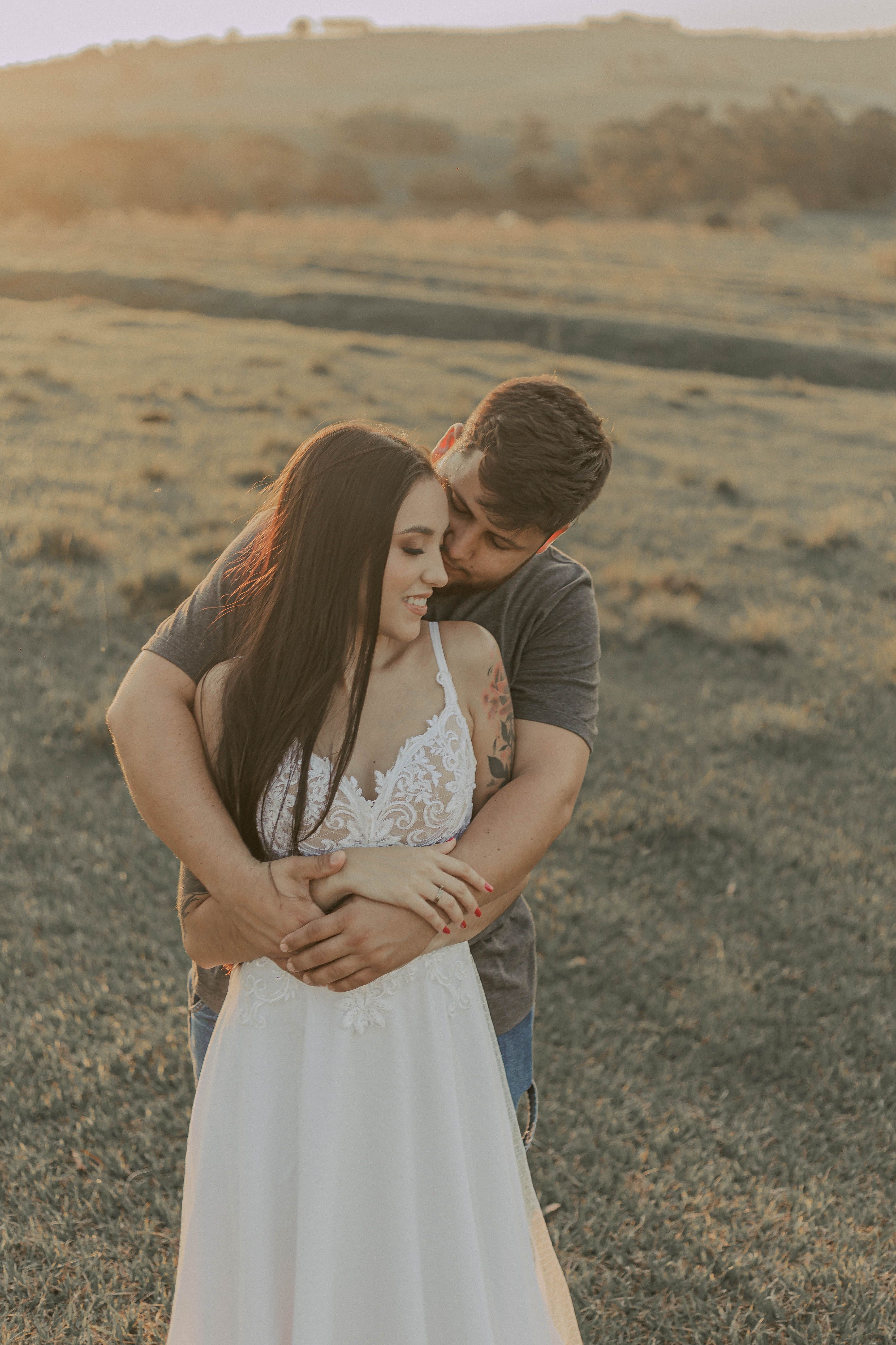Romantic Couple Embracing in Sunset Field · Free Stock Photo