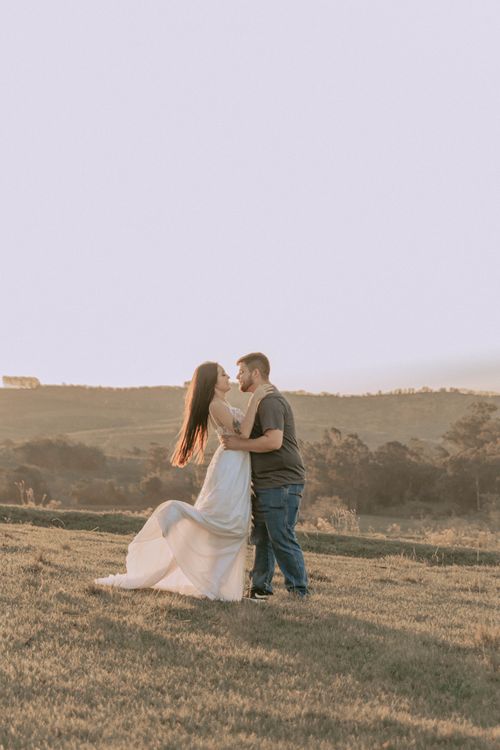 Free A couple embracing romantically in a serene outdoor setting during sunset. Stock Photo