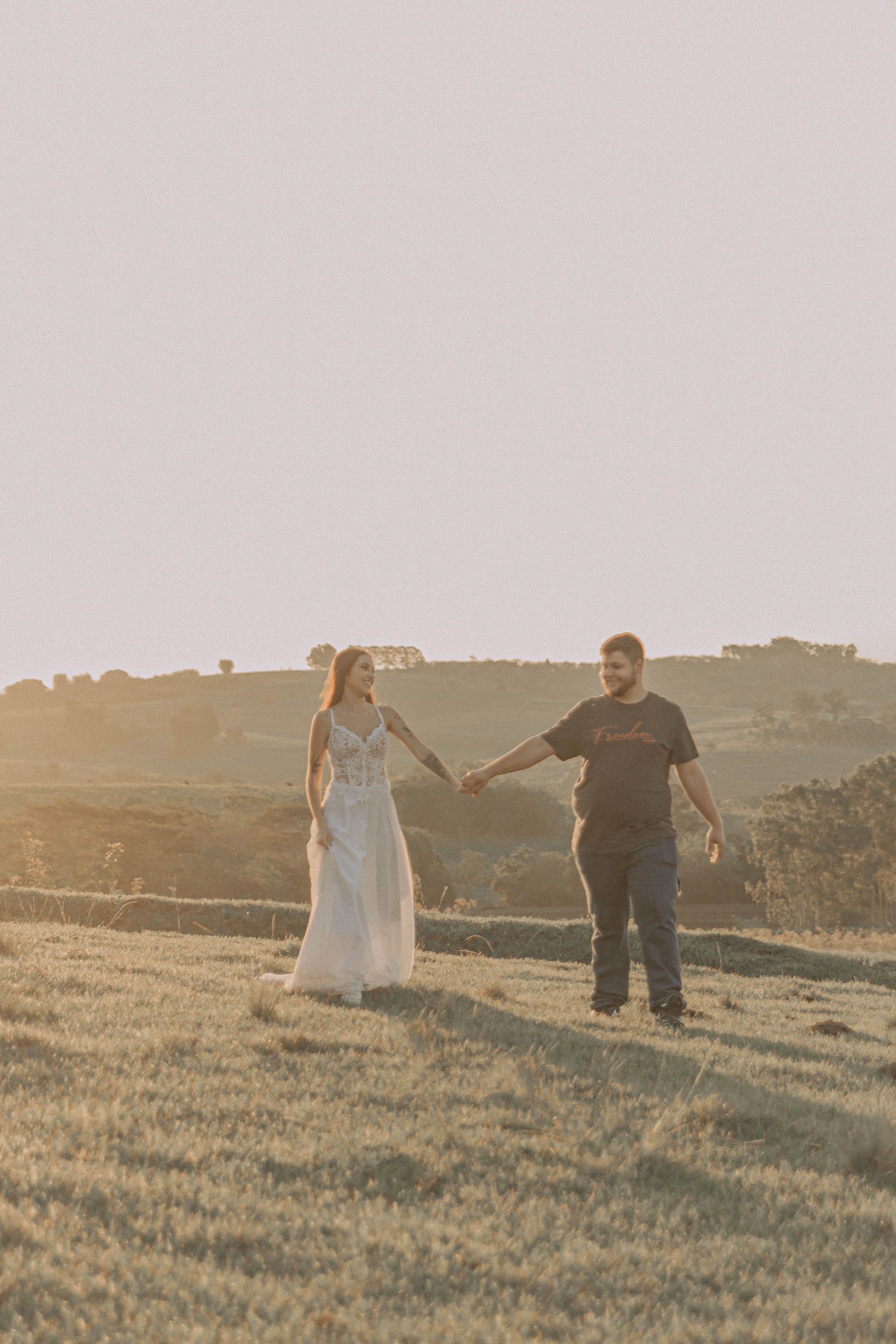 Romantic Couple Walking in Sunlit Field · Free Stock Photo