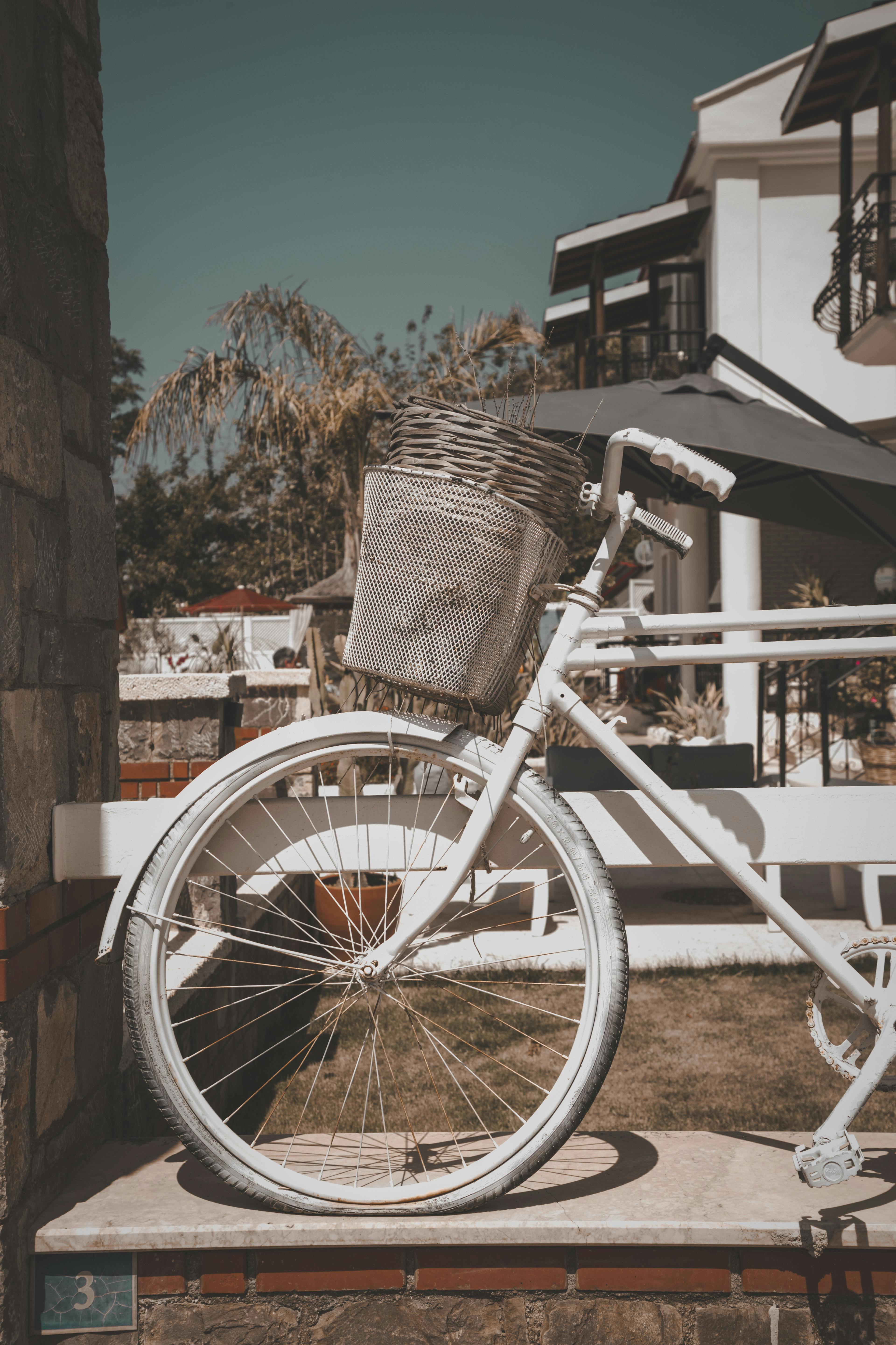 Free A charming vintage white bicycle with basket in front of a Mediterranean house in Türkiye. Stock Photo