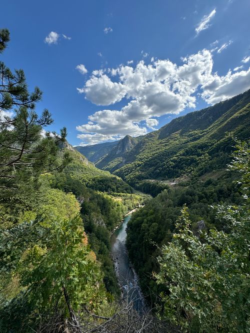Free Breathtaking view of a lush mountain valley with a winding river under a blue sky with clouds. Stock Photo