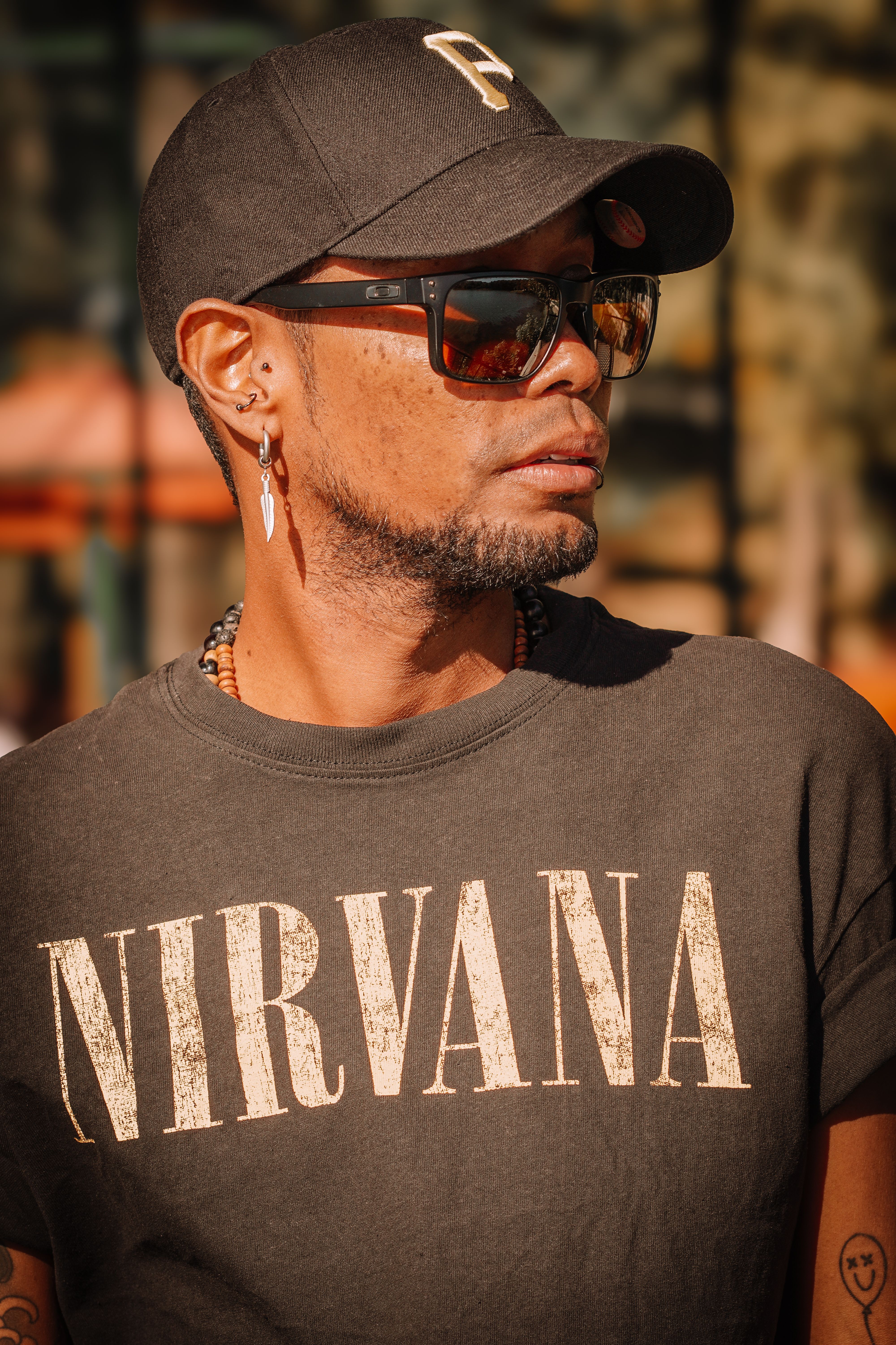 Stylish person wearing a Nirvana shirt and sunglasses outdoors in Tirana, Albania.