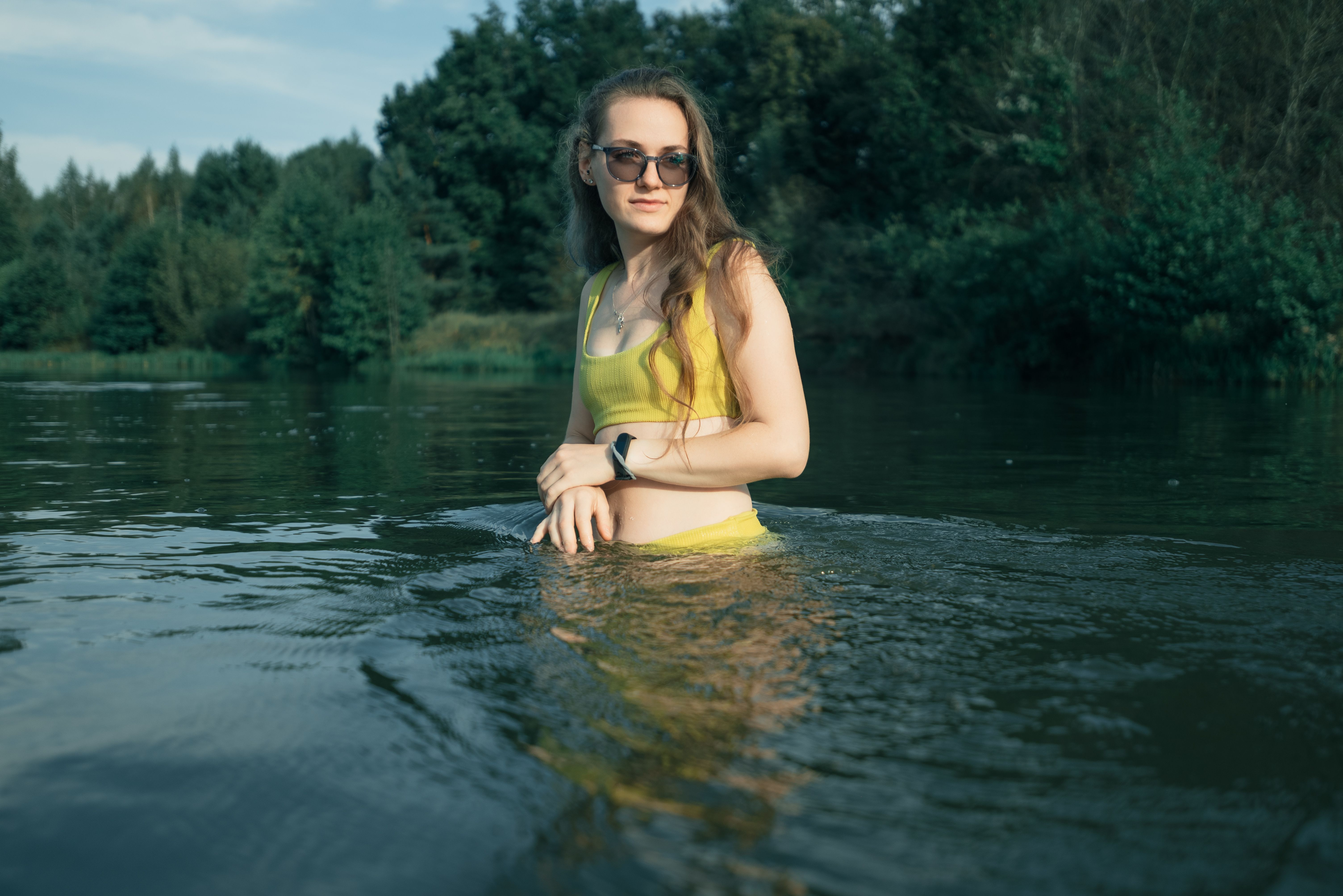Young woman in a yellow bikini enjoying a sunny day at the lake.