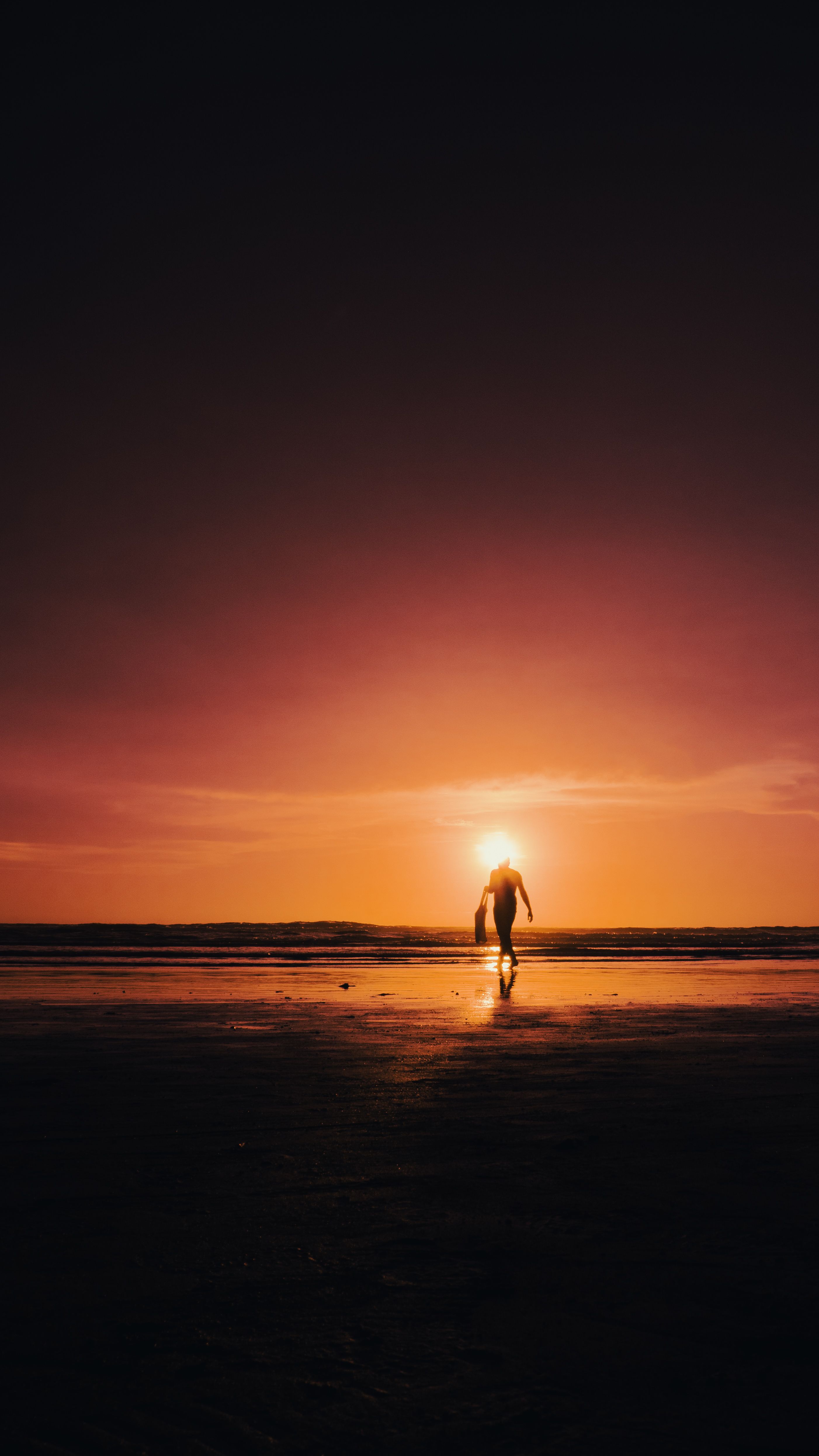 Silhouette of Person Walking on Beach at Sunset · Free Stock Photo