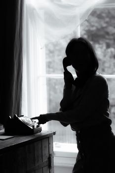 A silhouetted woman using a vintage telephone by a window, creating a nostalgic mood.