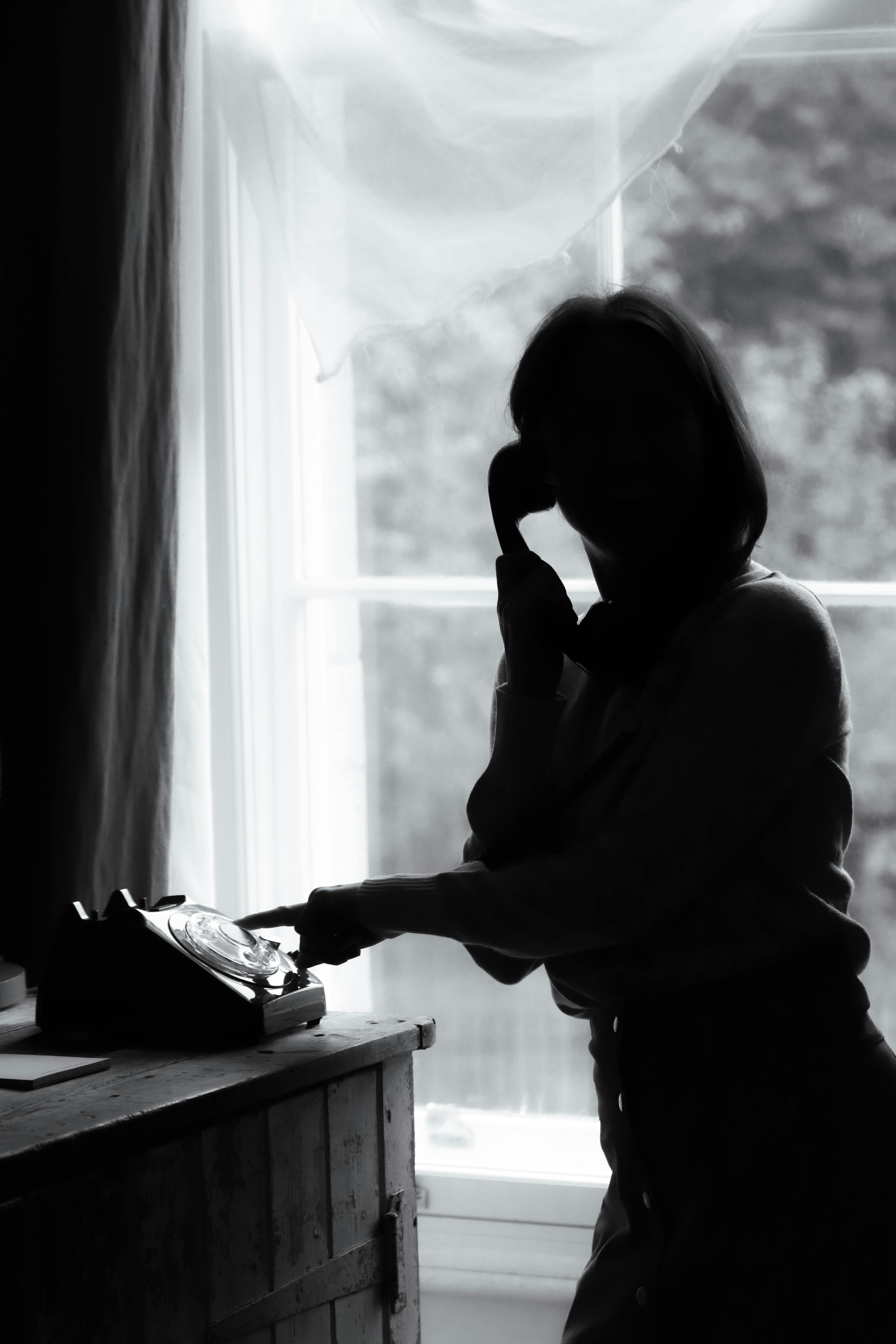 De franc Silueta De Dona Per Telèfon Vintage Amb Llum Suau Foto d'estoc