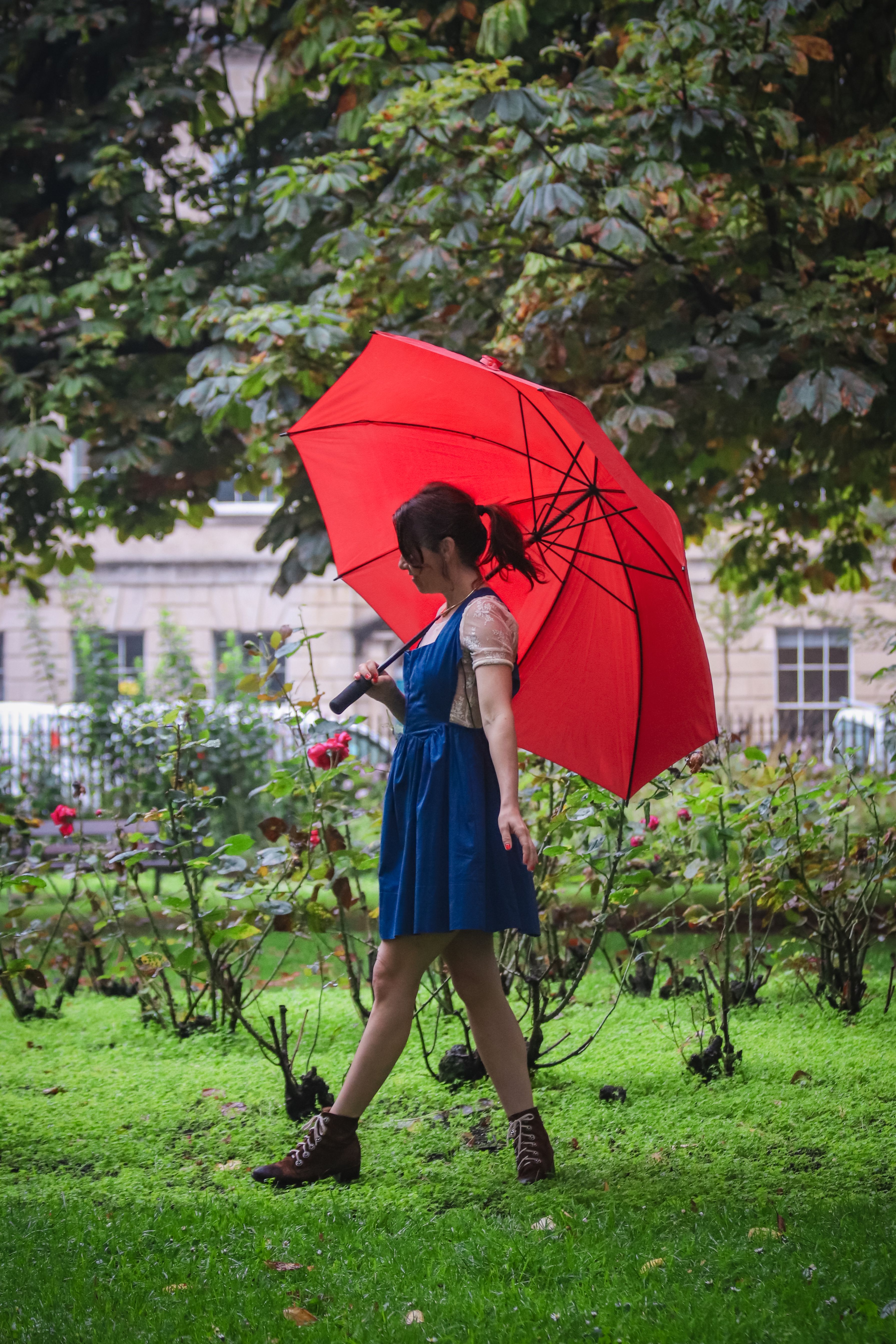 Woman with Red Umbrella Walking in a Garden · Free Stock Photo