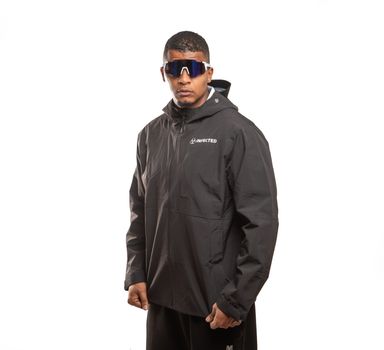 Model wearing a sleek black jacket with reflective sunglasses on a white background.