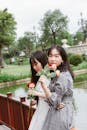 两名年轻女子拿着玫瑰，在公园度过了一天，展现了友谊与休闲