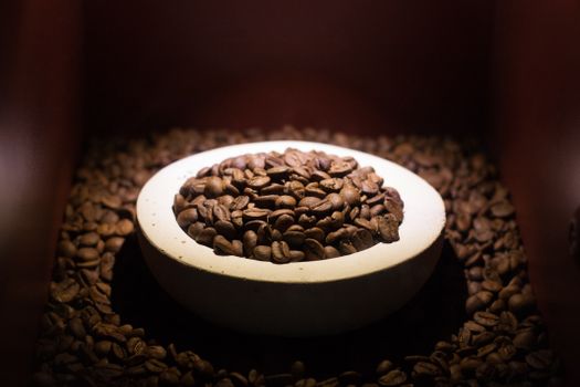 A close-up view of roasted coffee beans in a rustic bowl, creating an inviting warm atmosphere.