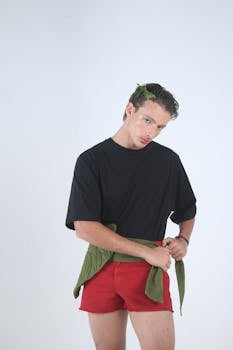 Minimalist fashion portrait of a young man with nature-inspired accessories.