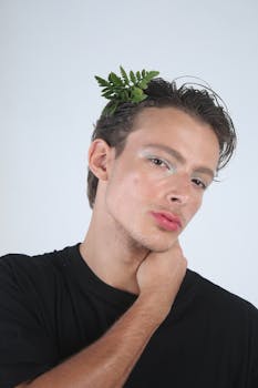 Fashion portrait of a young man with a leaf accessory, highlighting modern style and natural elements.