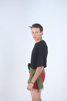 Side profile portrait of a young adult in stylish attire, minimalist backdrop.