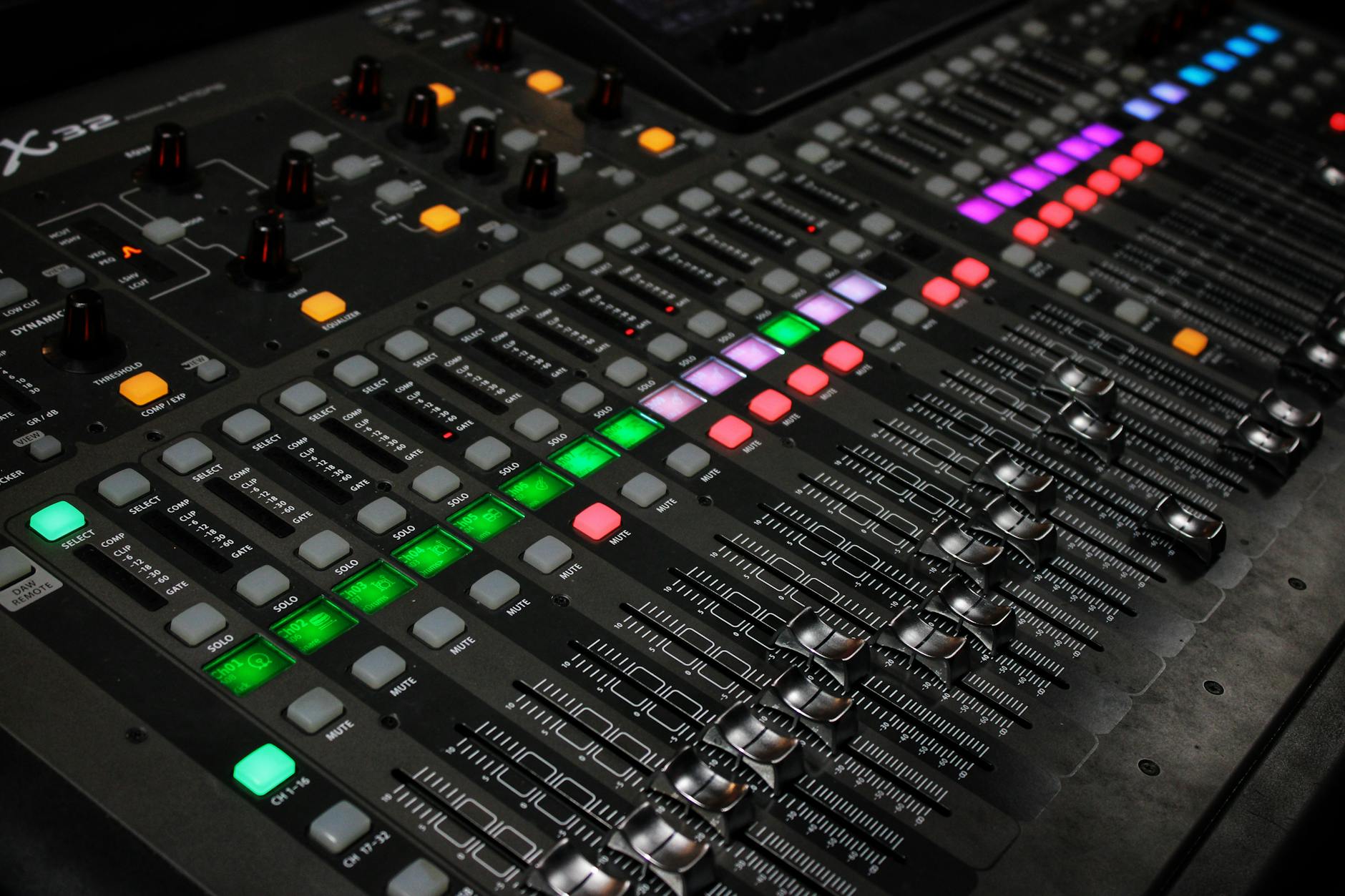 Detailed view of audio mixing console with glowing LED buttons.