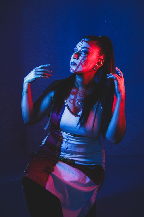Free A creative portrait of a woman in blue and red lighting with artistic makeup. Stock Photo