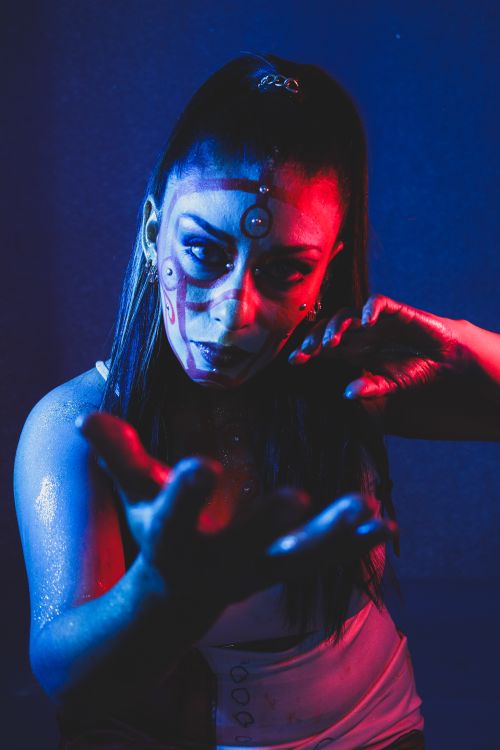 Free Artistic portrait featuring intense red and blue lighting with creative makeup effects. Stock Photo