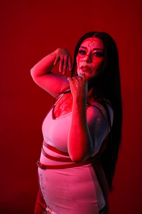 Free Captivating portrait of a woman with face paint, red lighting and dark hair. Stock Photo