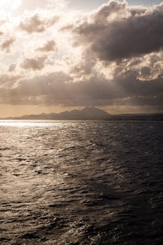 Gorgeous seascape featuring dramatic clouds and sunset rays over the ocean waves.