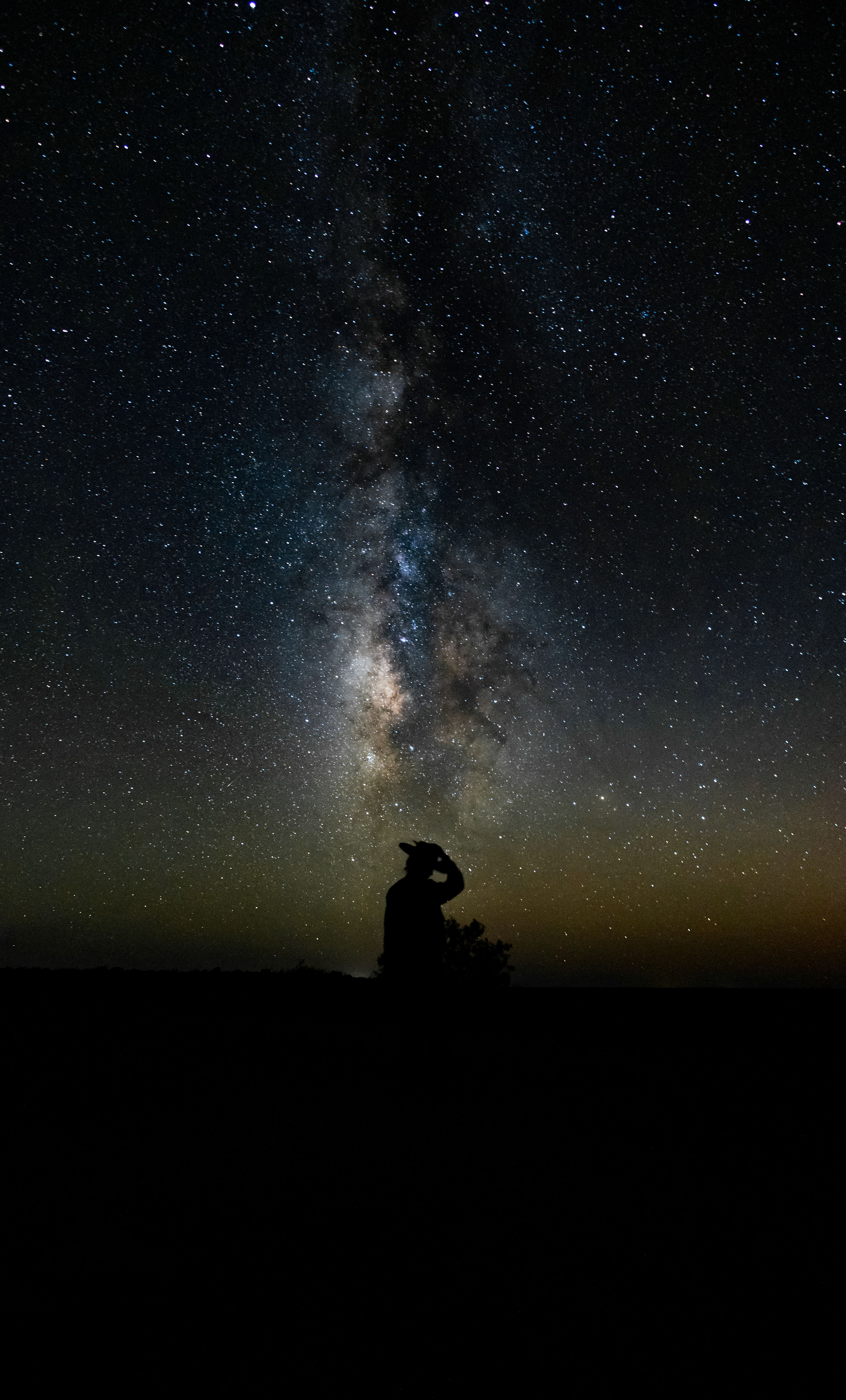 Silhouette of a Man Sitting on a Hill under a Starry Night Sky · Free ...