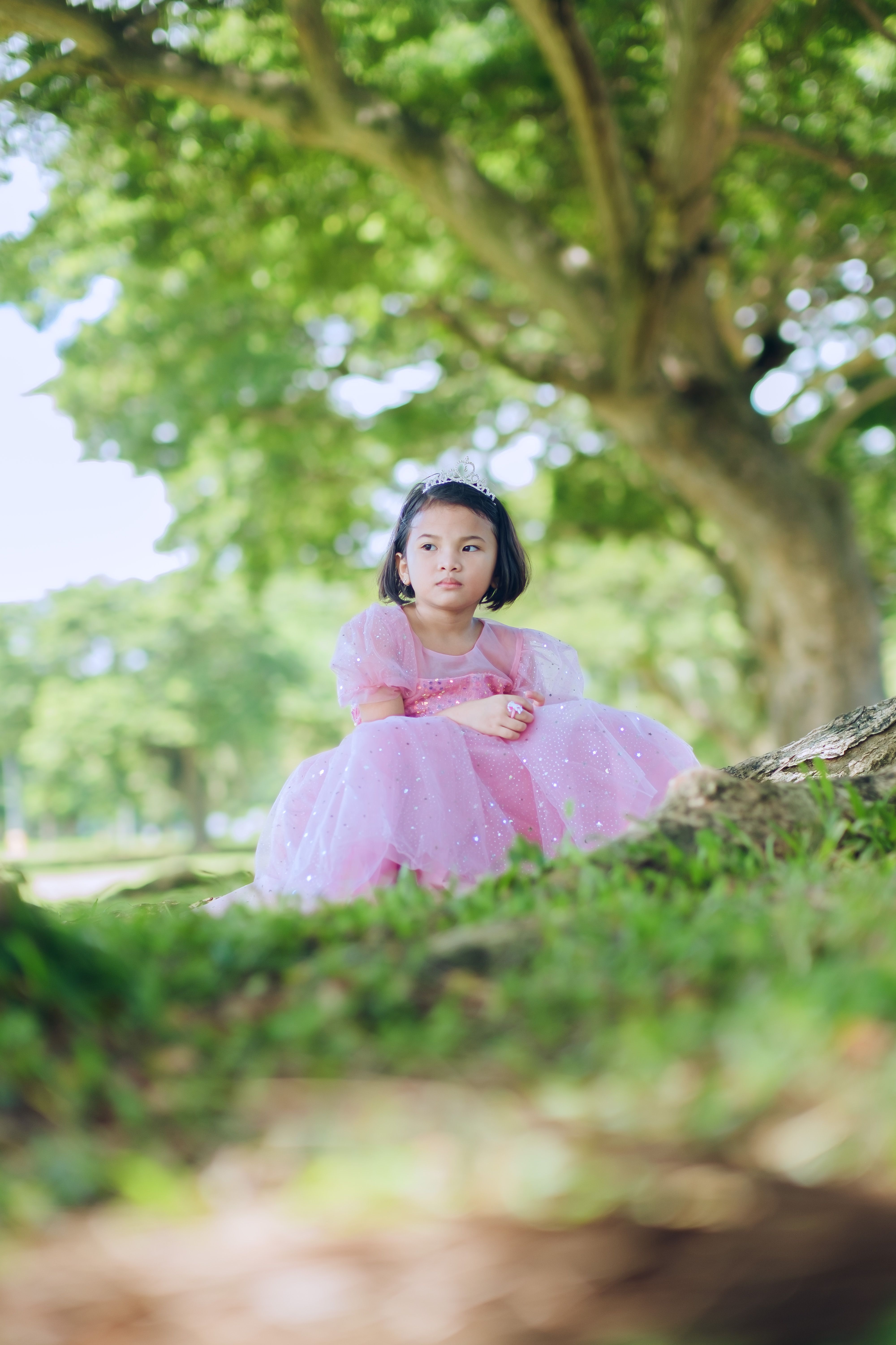 Young Girl in Pink Dress Sitting by Tree Outdoors · Free Stock Photo